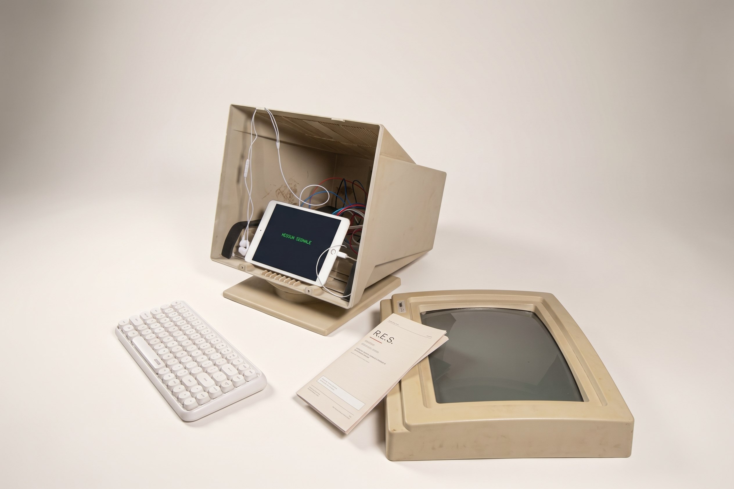 The installation from the side: the opened monitor with the iPad inside, the keyboard, the manual and the empty monitor frame next to it.